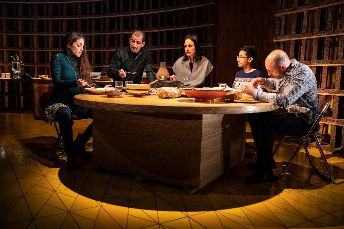 (L–R) Maryam (Dahlia Azama) visits with the Iraqi-American family, who include Tareq (Nabil Elouahabi), his wife Noura (Heather Raffo), and their son Yazen (Liam Campora), as well as the family’s friend Rafa'a (Matthew David), in “Noura.” (Joan Marcus)