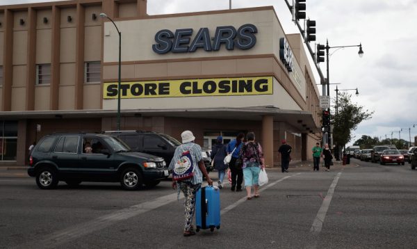 A sign announcing the store will be closing hangs above a Sears store