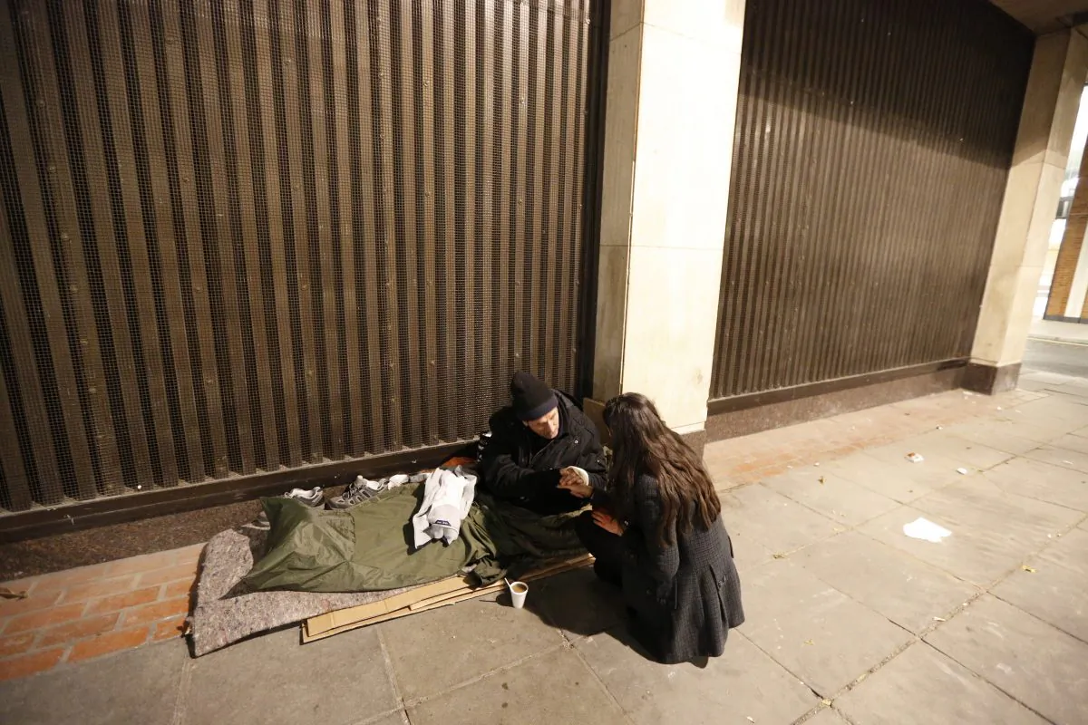 A homeless man grasps the hand of a volunteer who was handing out donated clothing, in central London on Dec. 13, 2012. (Reuters/Chris Helgren)