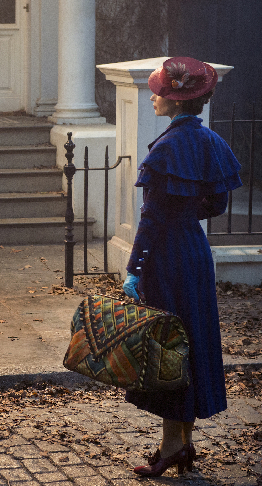 Mary Poppins stands outside Banks home