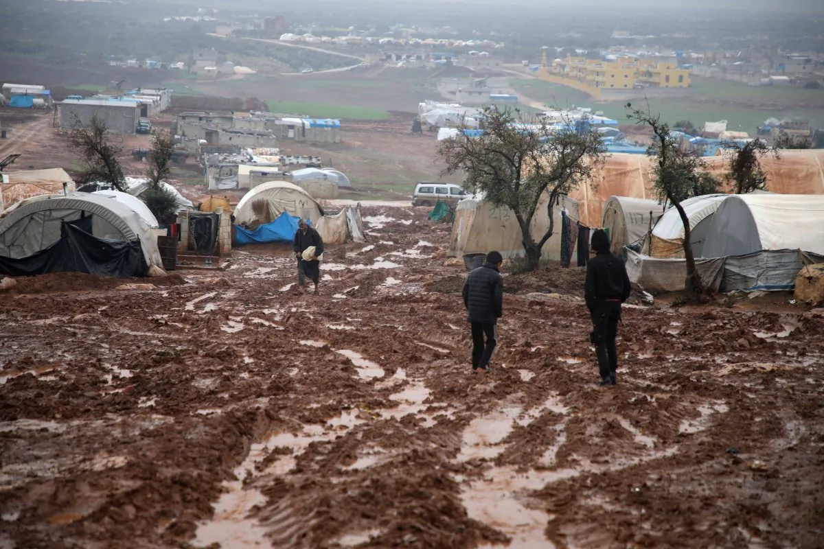 Syrian displaced people walk in a flooded camp near Kah, in the Idlib province, northeastern Syria, on Dec. 19, 2018. (Aaref Watad/AFP/Getty Images)