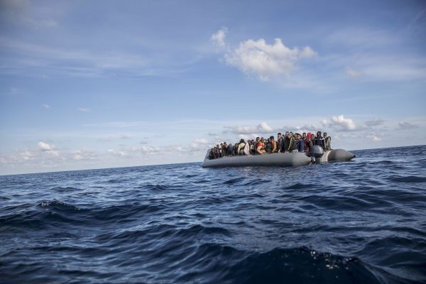 Migrants sit in rubber dinghy