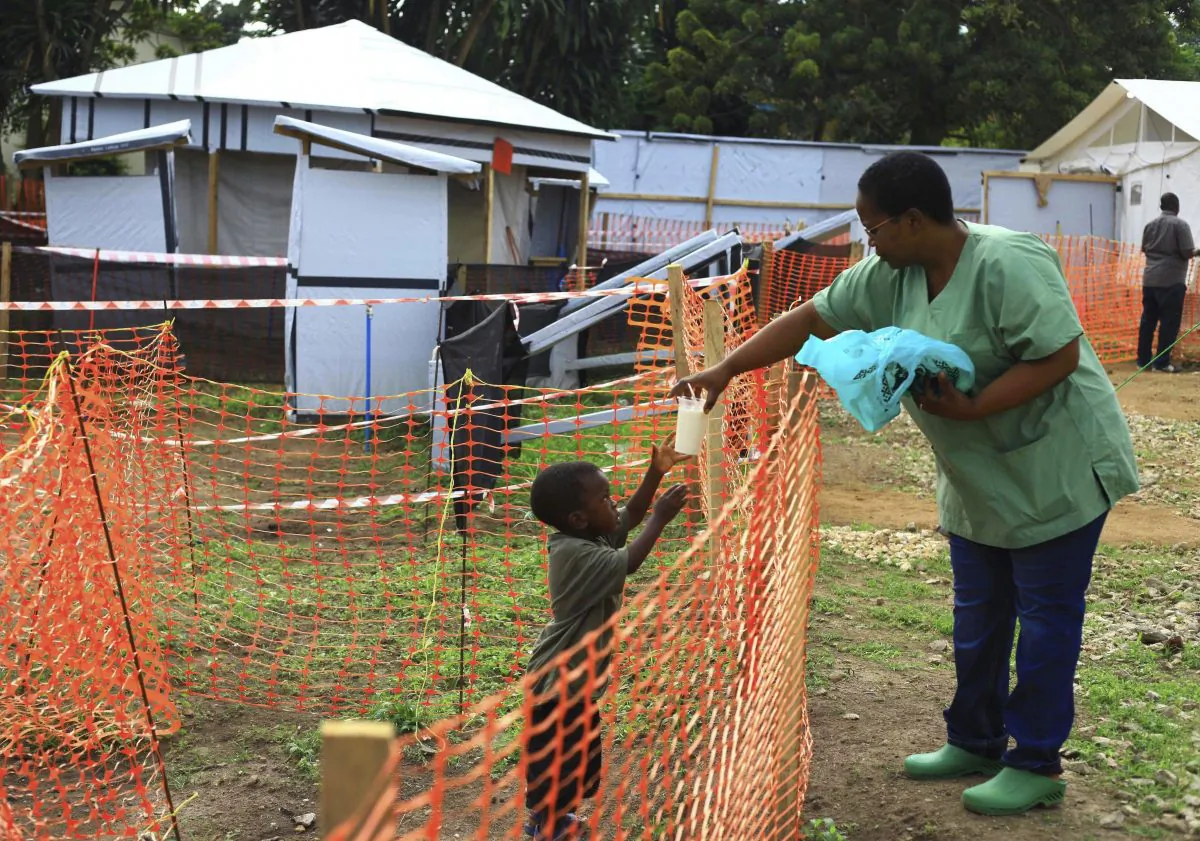 A health worker passes a drink to a boy suspecting of having the Ebola virus at an Ebola treatment center in Beni, Eastern Congo, on Sept 9, 2018. (AP Photo/Al-hadji Kudra Maliro)