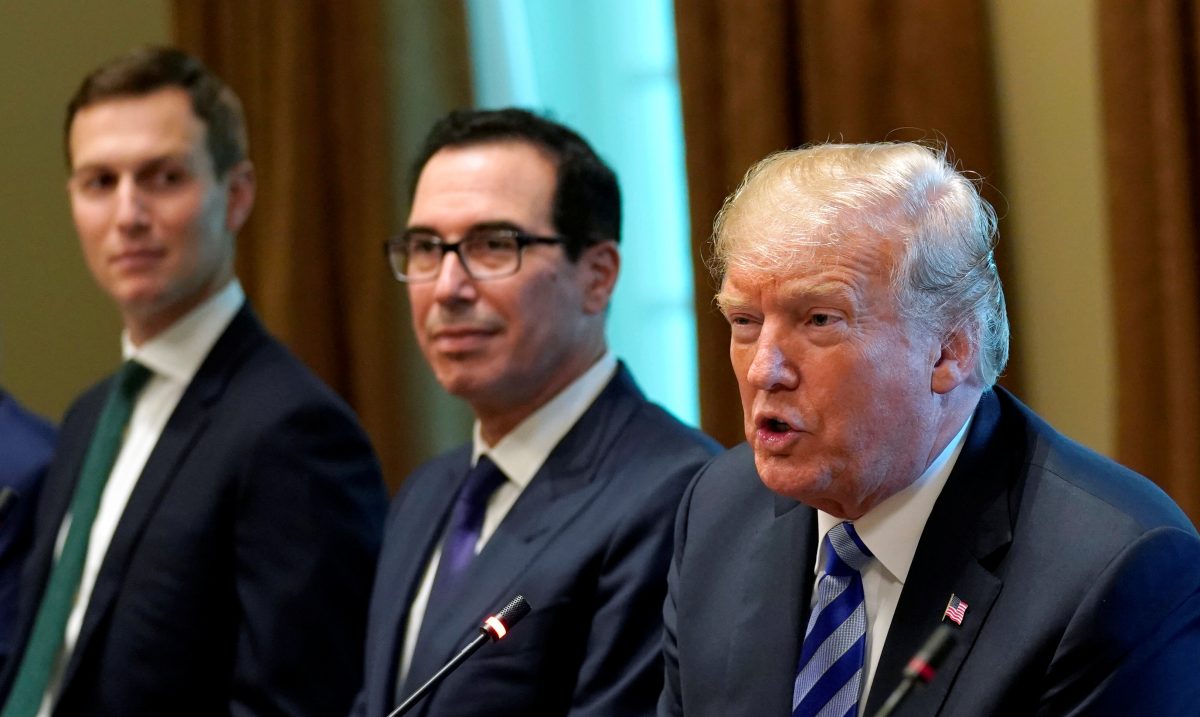 President Donald Trump, seated with Treasury Secretary Steve Mnuchin