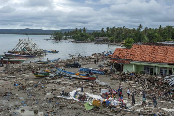 People inspect the damage at a tsunami-ravaged village in Sumur