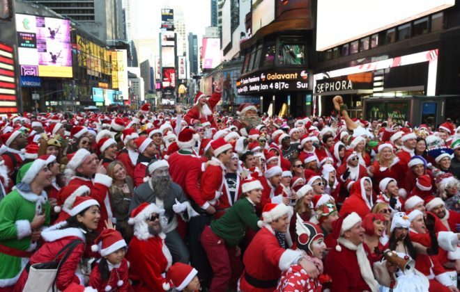 2014 年 12 月 13 日，人们打扮成圣诞老人和克劳斯夫人在纽约庆祝 Santacon 庆祝活动。  （唐埃默特/盖蒂图片社）