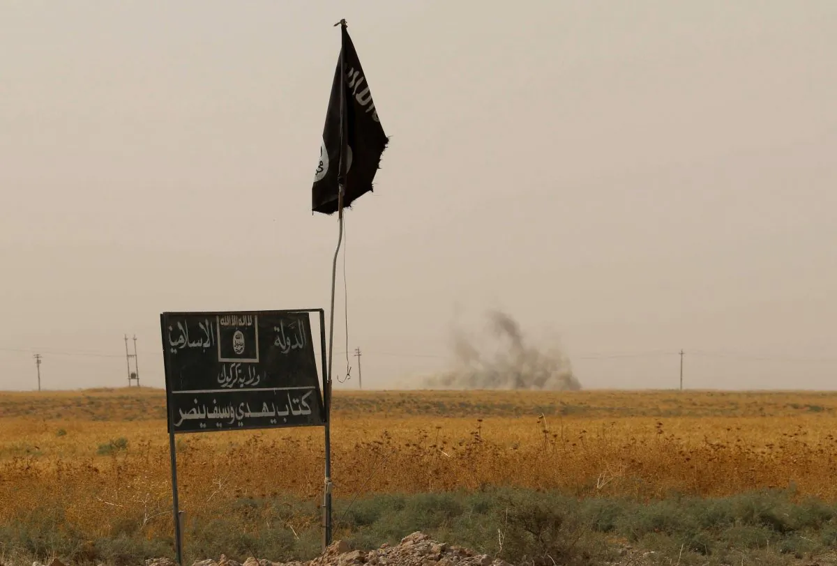Smoke rises in the distance behind an ISIS flag and banner. (Marwan Ibrahim/AFP/Getty Images)