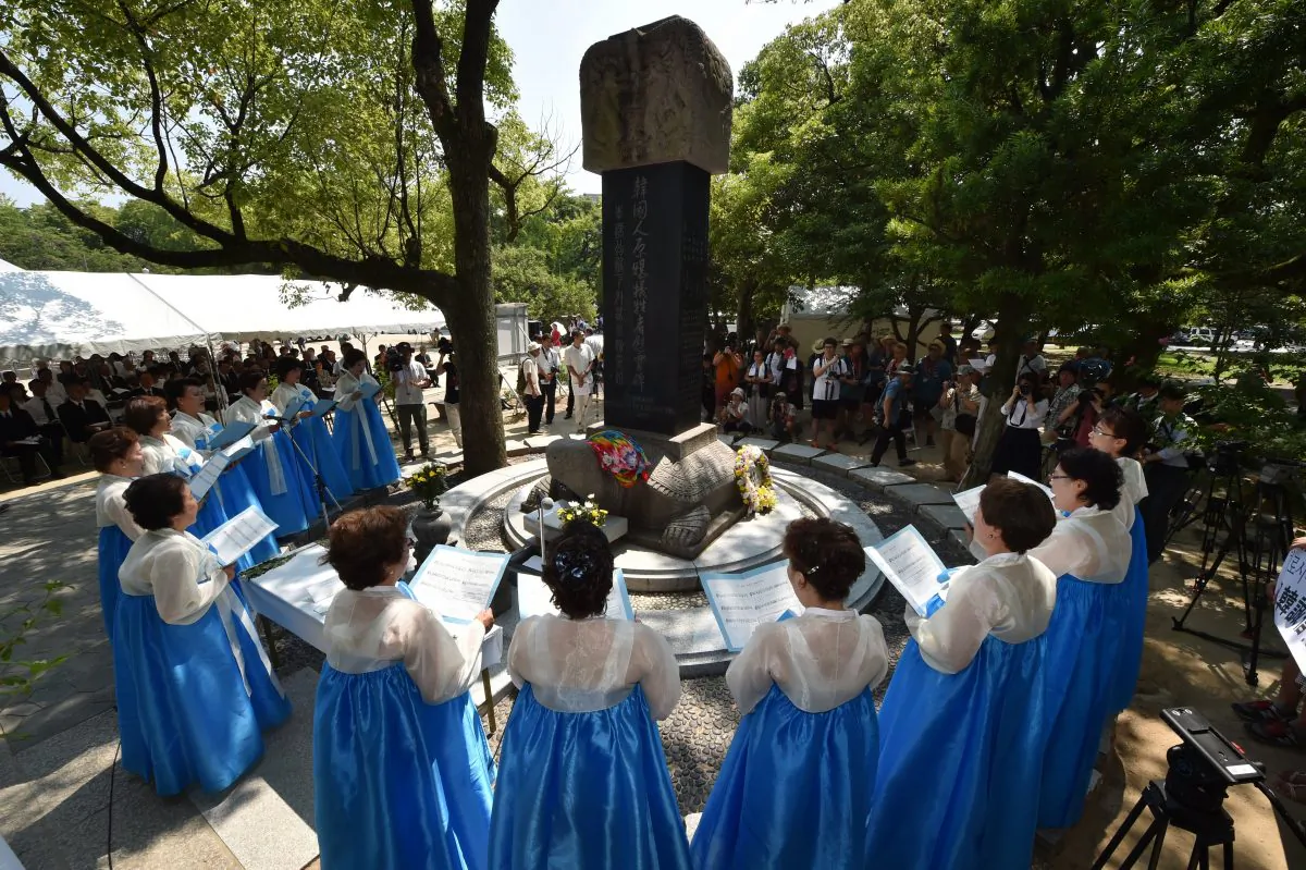 South Korean women clad in traditional costumes sing a song during a memorial service to pray for the Korean victims of the 1945 atomic bombing, before a monument at the Peace Memorial Park in Hiroshima on Aug. 5, 2015. (KAZUHIRO NOGI/AFP/Getty Images)