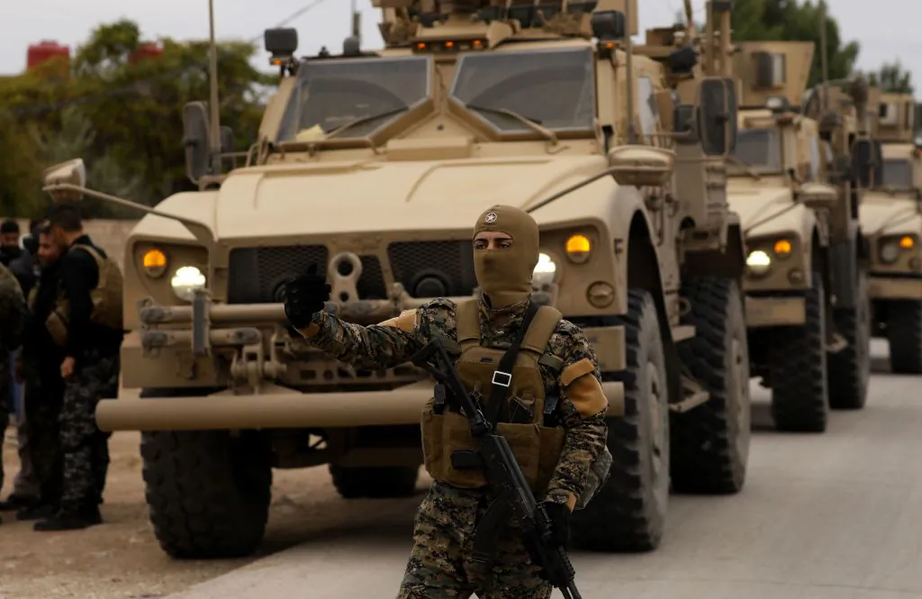 Members of the Syrian Democratic Forces and US soldiers patrol the Kurdish-held town of Al-Darbasiyah in northeastern Syria on Nov. 4, 2018. (Delil Souleiman/AFP/Getty Images)