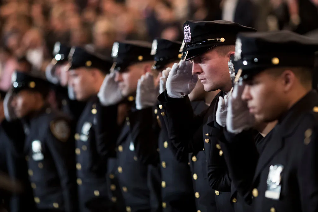 The newest members of the New York City Police Department (NYPD) salute during their police academy graduation ceremony at the Theater at Madison Square Garden, March 30, 2017 in New York City. (Drew Angerer/Getty Images)