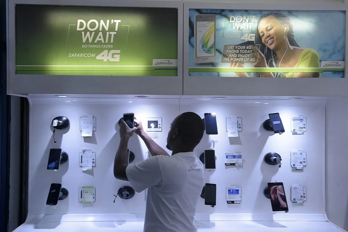 An employee arranges a display of smartphones at a Safaricom shop in Nairobi, Kenya, on Nov. 22, 2018. Chinese telecoms giant Huawei has partnered with Safaricom to roll out 4G networks. (SIMON MAINA/AFP/Getty Images)