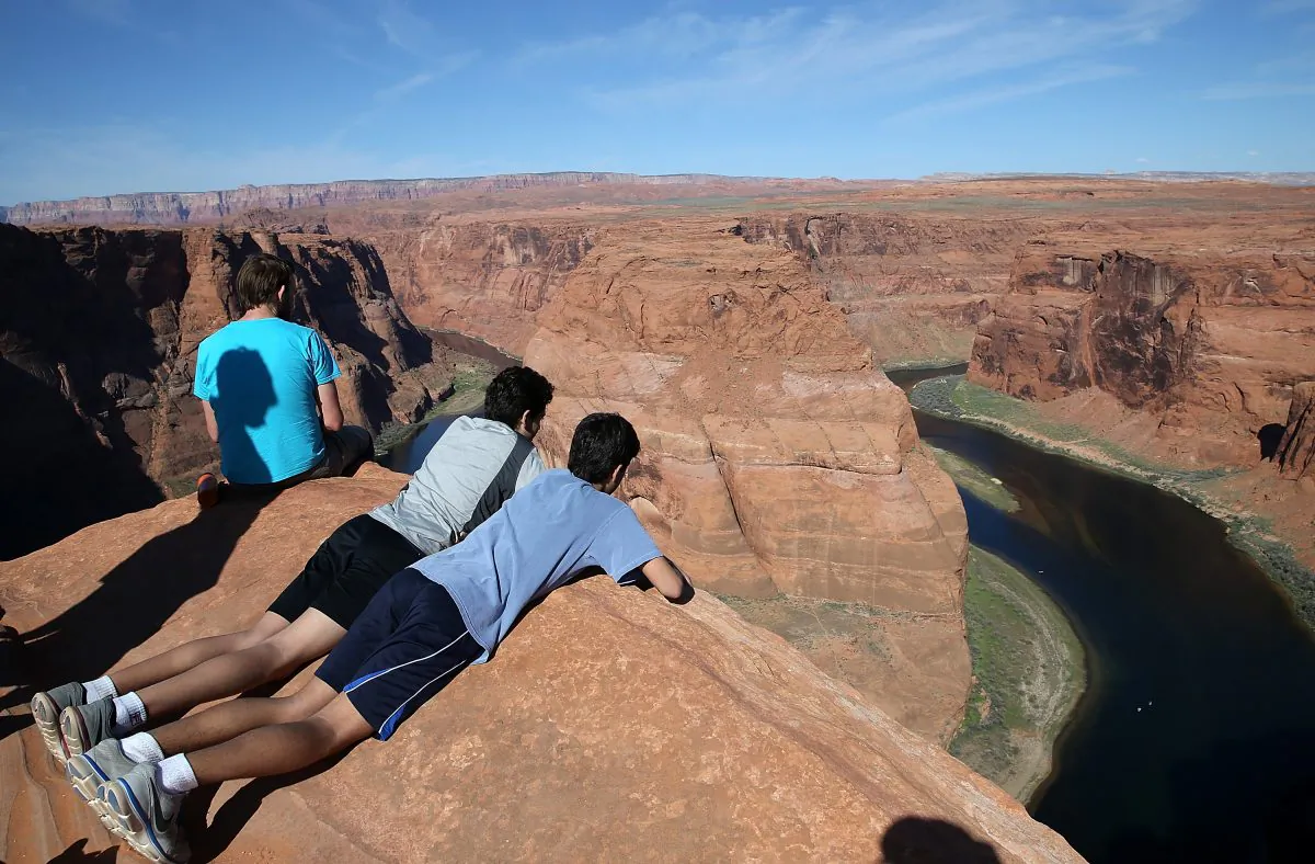 People lie on the edge of a cliff to view the Colorado River at Horseshoe Bend on March 30, 2015, in Page, Arizona. (Justin Sullivan/Getty Images)