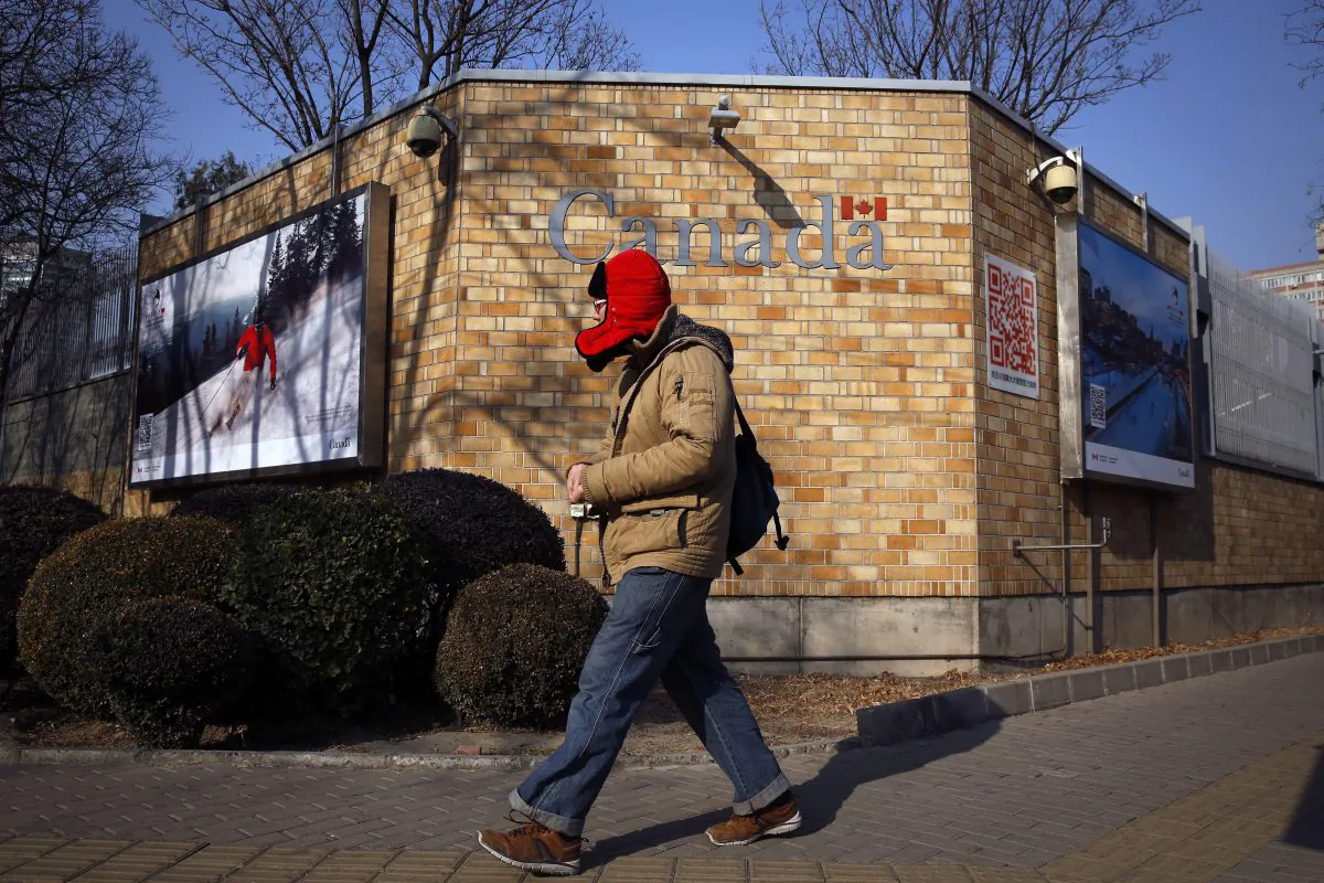 A man walks by the Canadian Embassy in Beijing, on Dec. 14, 2018. (AP Photo/Andy Wong)
