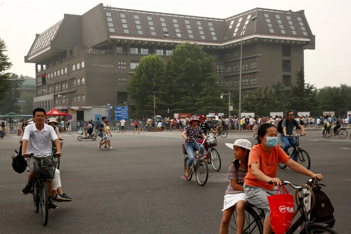 People cycle past a building in Peking University in Beijing, China on July 27, 2016.  (Thomas Peter/Reuters)