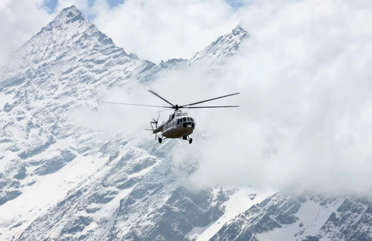 A Russian helicopter flies past Mount Thamserku in Syangboche, Nepal, on April 6, 2018. (AP Photo/Tashi Sherpa)