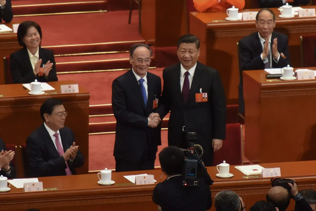 Chinese paramount leader Xi Jinping (R) and Chinese Vice Chair Wang Qishan (2-L) shake at the Great Hall of the People in Beijing, China on March 17, 2018.  (Etienne Oliveau/Getty Images)