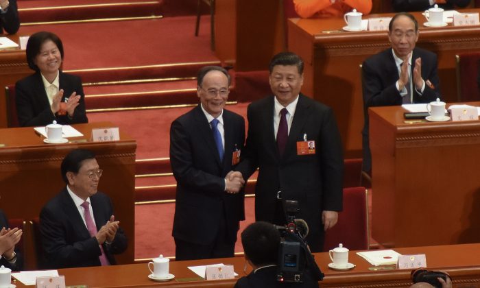 Chinese paramount leader Xi Jinping (R) and Chinese Vice Chair Wang Qishan (2-L) shake at the Great Hall of the People in Beijing, China on March 17, 2018.  (Etienne Oliveau/Getty Images)