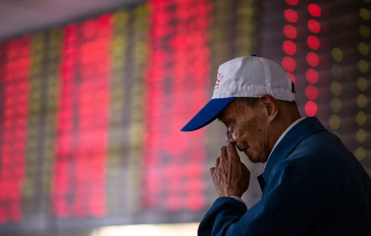 An investor looks at an electronic board showing stock information at a brokerage house in Shanghai Oct. 15. (Johannes Eisele/AFP/Getty Images)