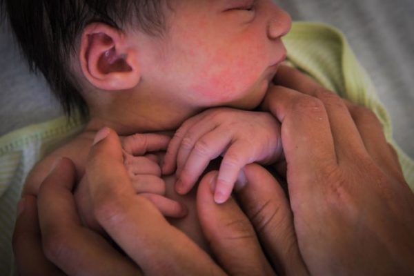 A mother holds her newborn baby.