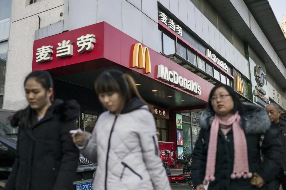 People walk past a McDonald's fast food restaurant in Beijing. (FRED DUFOUR/AFP/Getty Images)