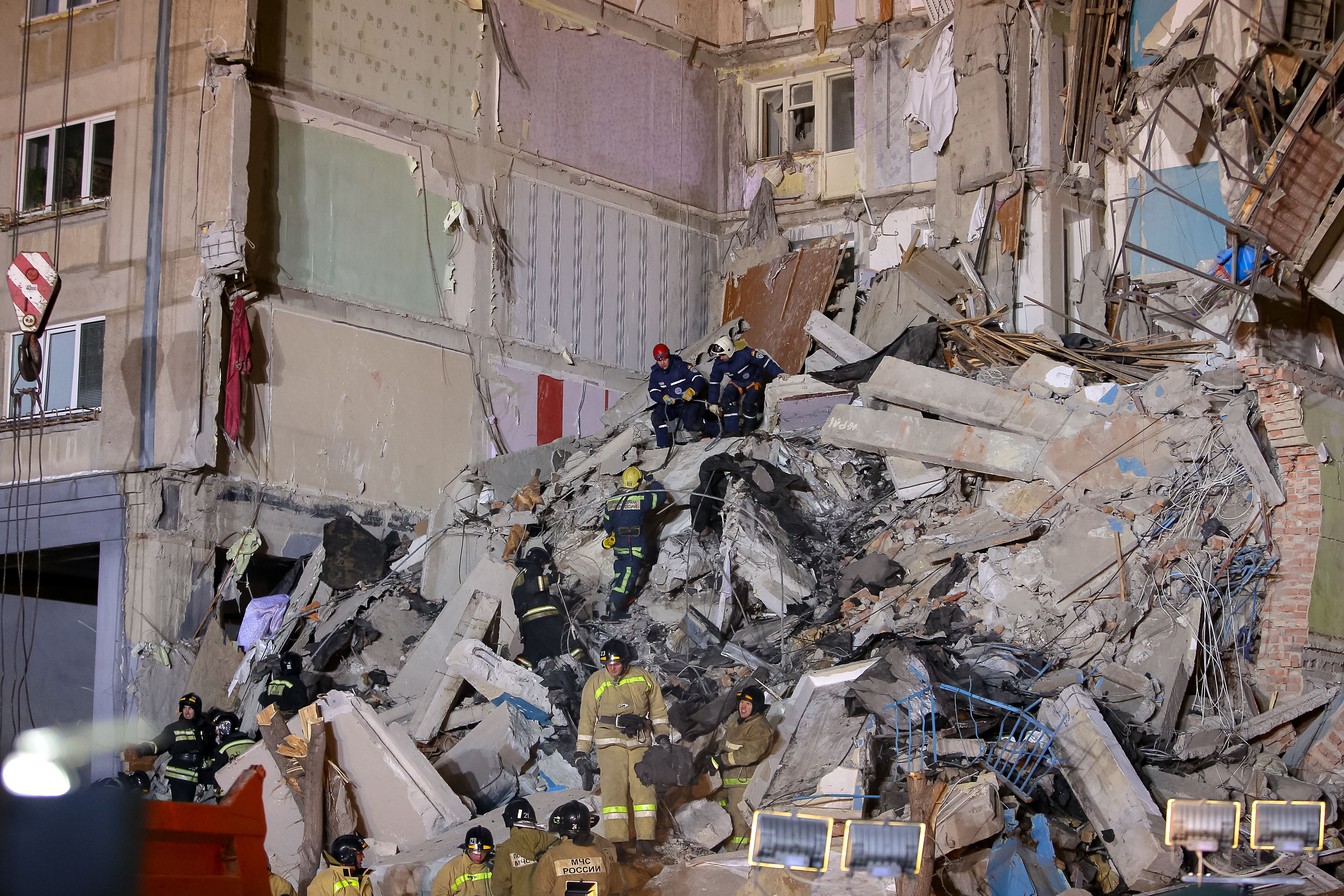 Emergency officers inspect rubble as they take part in a rescue operation after a gas explosion rocked a residential building in Russia's Urals city of Magnitogorsk