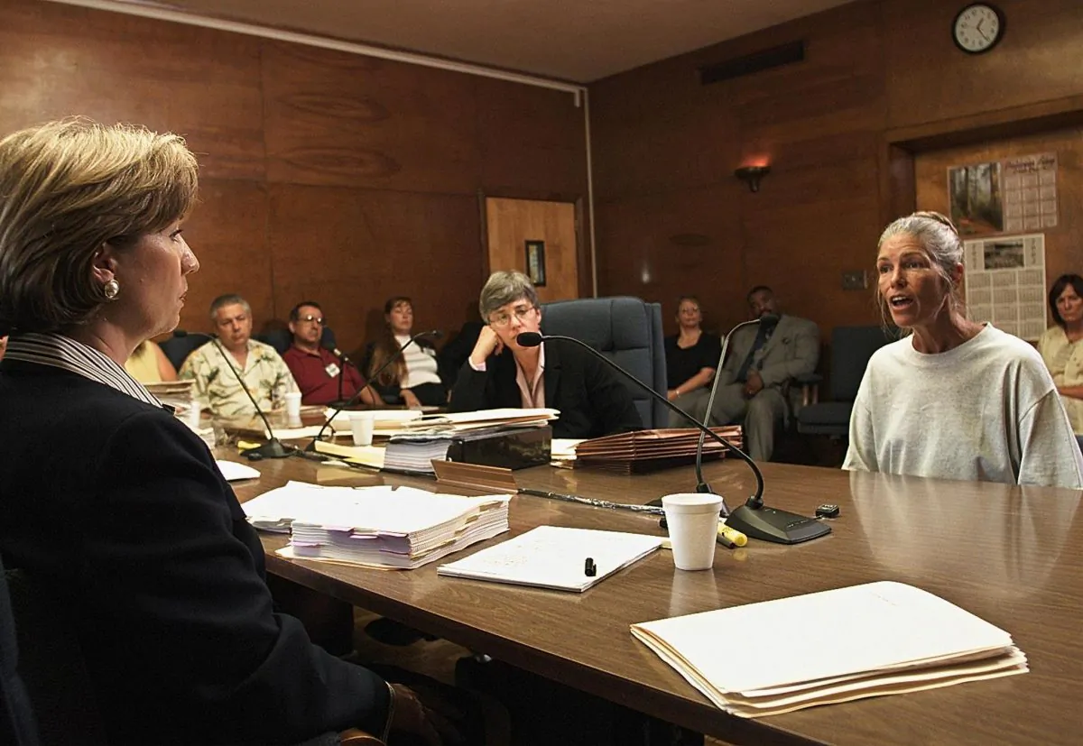 Sheron Lawin (L), a member of the Board of Prison Terms commissioners, listens to Leslie Van Houten (R), after her parole was denied 28 June 2002 at the California Institution for Women in Corona, California. Van Houten, 53, has served over 30 years in prison for her involvement in the Tate-LaBianca killings. Van Houten's attorney Christie Webb is at center. (Damian Dovarganes/AFP/Getty Images)