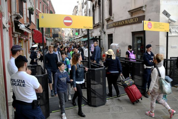 Venice's citizens and tourists pass through turnstiles