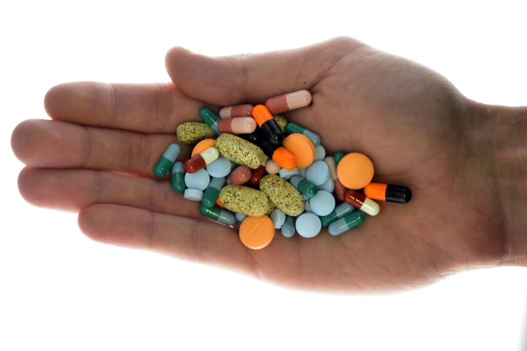 A person holds pharmaceutical tablets and capsules in this picture illustration taken on Sept. 18, 2013. (Srdjan Zivulovic/Reuters)