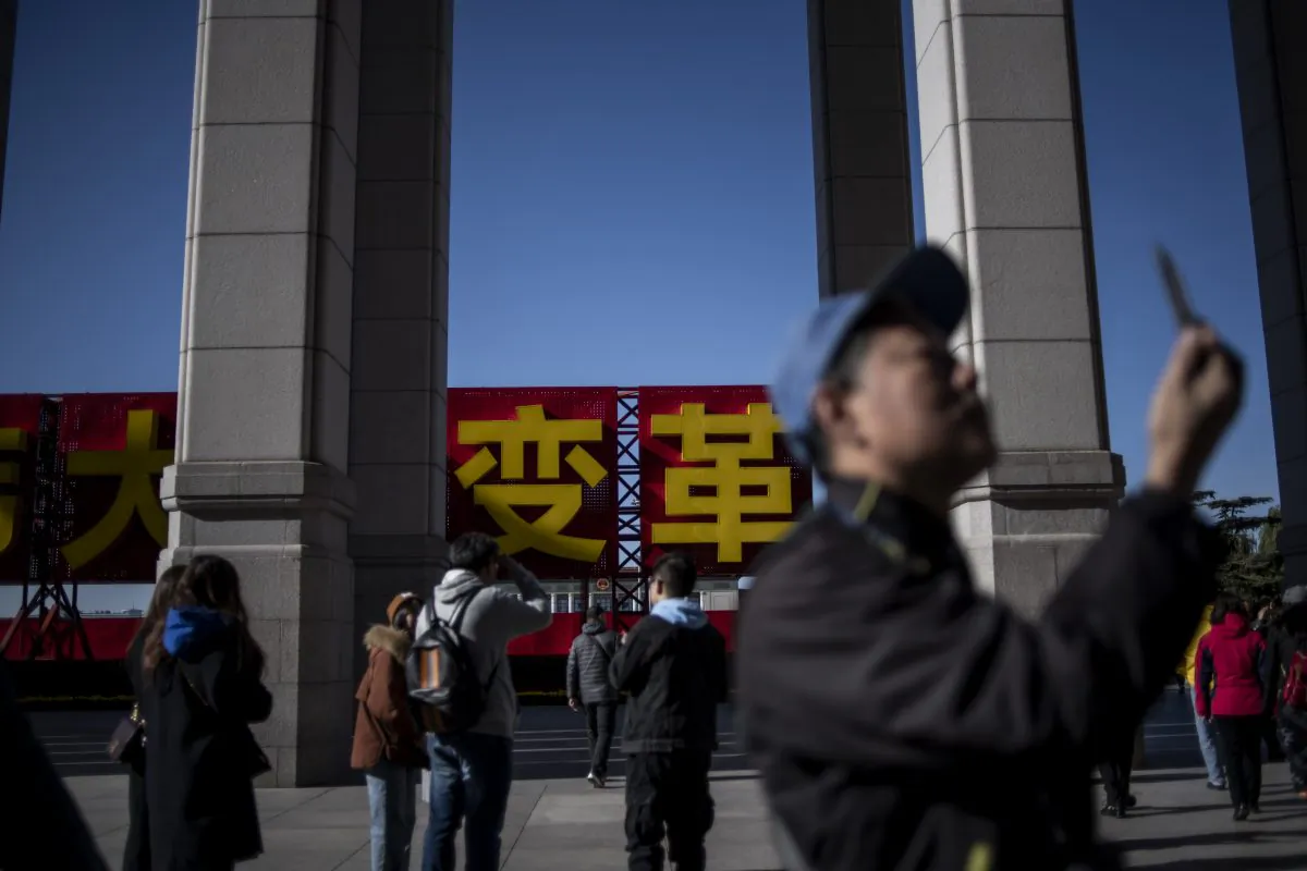 Tourists take pictures at the entrance of an exhibition marking the 40th anniversary of China's reform and opening up, at the National Museum of China in Beijing on Nov. 16, 2018. (Fred Dufou/AFP/Getty Images)