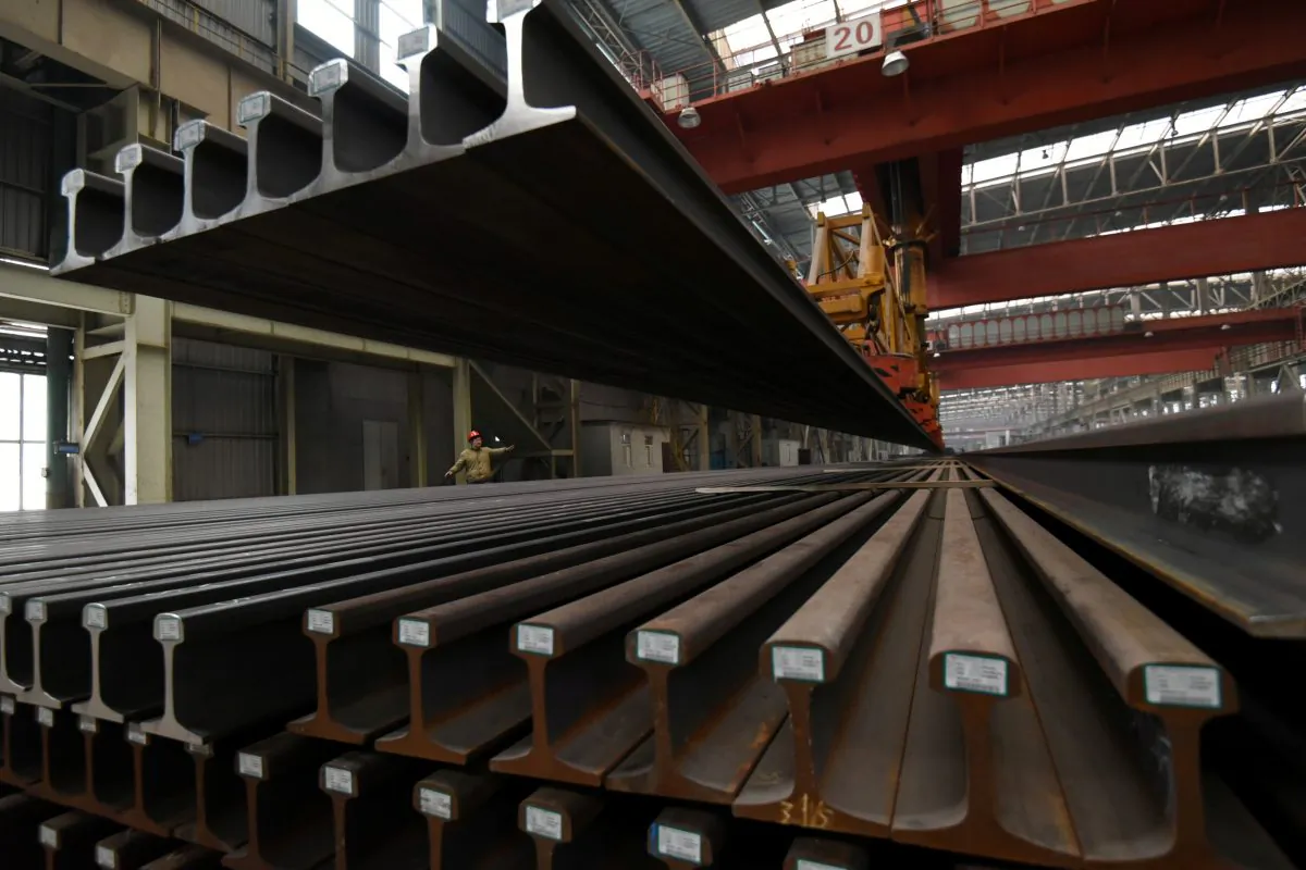 A worker directs a crane lifting steel rails at a steel factory in Handan, Hebei Province, China on Nov. 23, 2018. (Reuters)