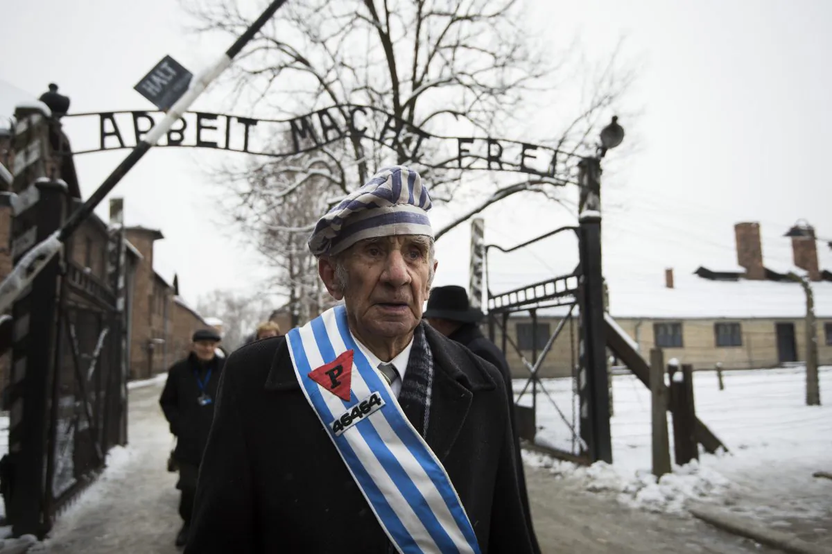 Auschwitz survivor Miroslaw Celka walks out of the death camp gate with the sign above it saying "Work makes you free,” on the 70th anniversary of the liberation of the Nazi extermination facility in southern Poland, on Jan. 27, 2015. (Odd Andersen/AFP/Getty Images)