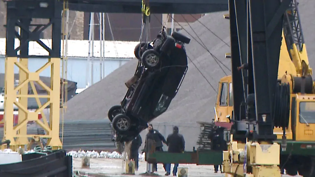 This Jan. 1, 2019 screen shot from WISN-TV shows authorities pulling out an SUV from the Kinnickinnic River, a day after it crashed into the river during a police chase. (WISN-TV via AP)