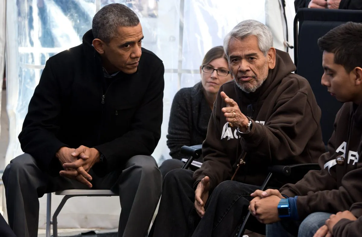 Former President Barack Obama (L) listens to Eliseo Medina and other people taking part in the Fast for Families on the National Mall in Washington on Nov. 29, 2013. Obama offered support for those fasting for immigration reform. (NICHOLAS KAMM/AFP/Getty Images)