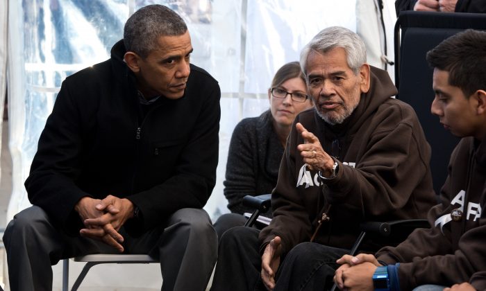 Former President Barack Obama (L) listens to Eliseo Medina and other people taking part in the Fast for Families on the National Mall in Washington on Nov. 29, 2013. Obama offered support for those fasting for immigration reform. (NICHOLAS KAMM/AFP/Getty Images)