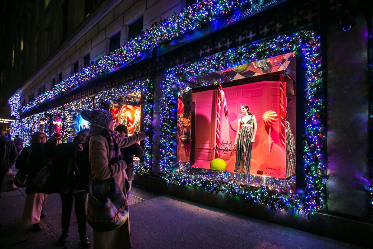 People stop to look at holiday window displays at the Saks Fifth Avenue store in New York City on Dec. 20, 2016. (Benjamin Chasteen/Epoch Times)