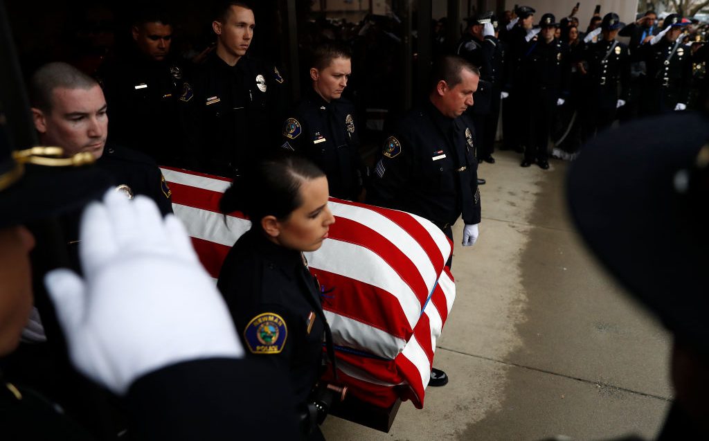 Officers carry the flag-draped casket of slain officer Ronil Singh