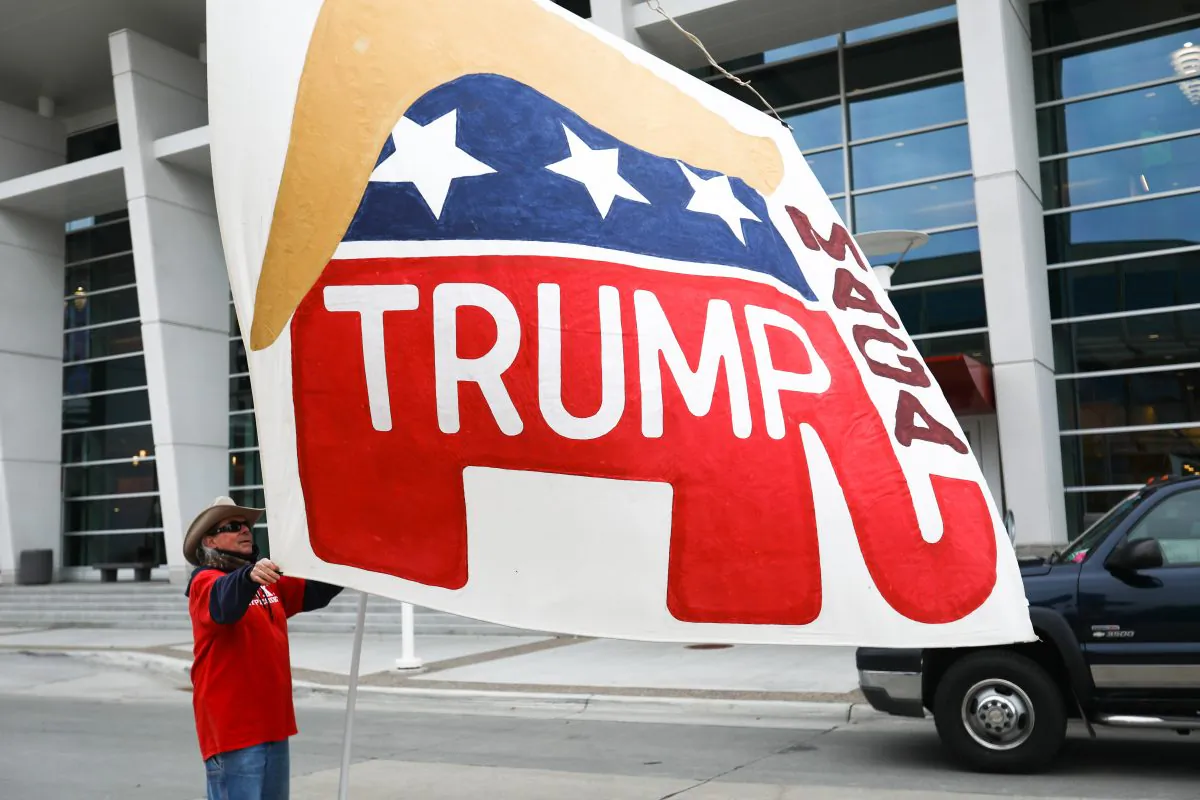 A Trump supporter waves a giant, handmade flag outside a Make America Great Again rally in Rochester, Minn., on Oct. 4, 2018. (Charlotte Cuthbertson/The Epoch Times)