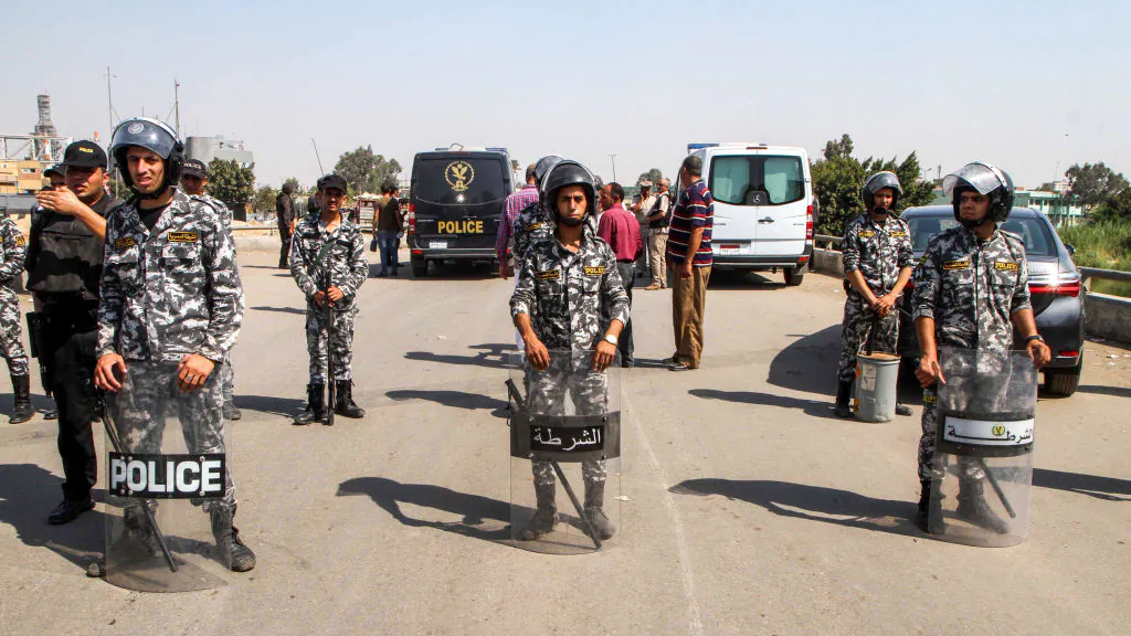 Members of the Egyptian security forces form a perimeter for investigators gathered around the body of a suicide bomber, whose explosives detonated before reaching the Coptic Orthodox Church of the Virgin Mary, in the eastern Mostorod neighbourhood of the district of Shubra al-Kheima on the northern outskirts of the capital Cairo, on August 11, 2018. - Egypt's state media reported that the alleged bomber, who was reportedly hiding the explosives under a fluorescent vest, was forced to detonate a suicide belt 200 metres away from the church as a result of the heavy police presence around it. Christian sites of worship across Egypt have been repeatedly targeted in attacks claimed by the Islamic State group. (Photo by STRINGER / AFP)        (Photo credit should read STRINGER/AFP/Getty Images)