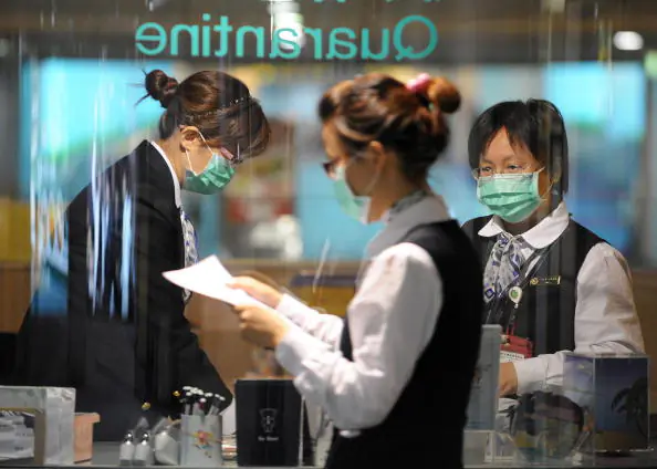 Masked Taiwan government quarantine staffs stand by a check point at the Taoyuan International Airport on April 28, 2009. (Sam Yeh/AFP/Getty Images)