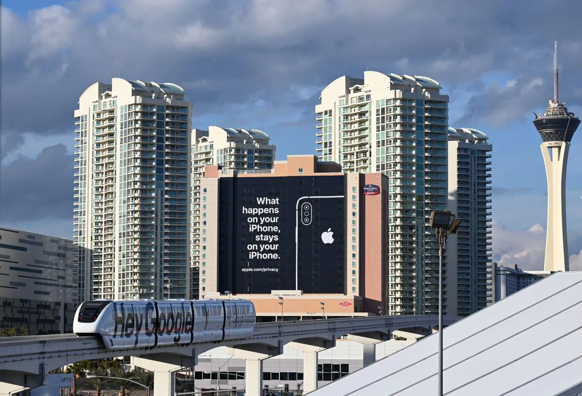 A monorail train plastered with a Google advertisement passes a giant sign from Apple on a building as preparations are underway for the CES 2019 show, Jan. 6, 2019, in Las Vegas, Nevada. Apple is taking a shot at rivals such as Google on the data privacy front with the message reading "What happens on your iPhone stays on your iPhone." (ROBYN BECK/AFP/Getty Images)