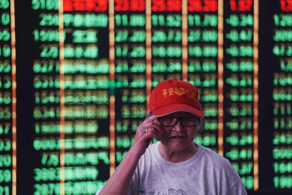 An investor stands in front of a screen displaying stock market figures at a securities company in Hangzhou in China's Zhejiang Province on June 19, 2018. (AFP/Getty Images)