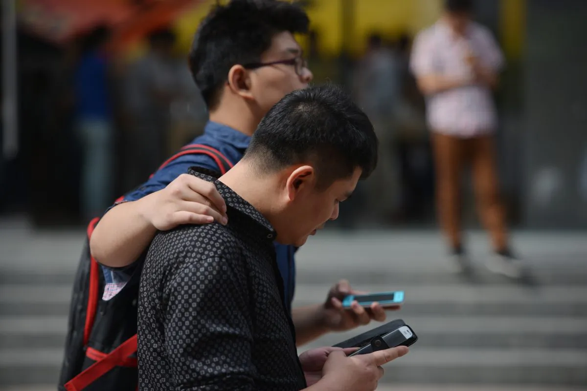 Chinese citizens use their cellphones on a street in Shanghai on Sept. 25, 2013. (PETER PARKS/AFP/Getty Images)
