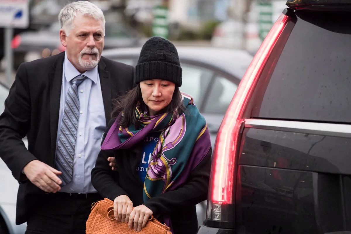 Huawei chief financial officer Meng Wanzhou, right, arrives at a parole office with a member of her private security detail in Vancouver, on Dec. 12, 2018. (THE CANADIAN PRESS/Darryl Dyck)