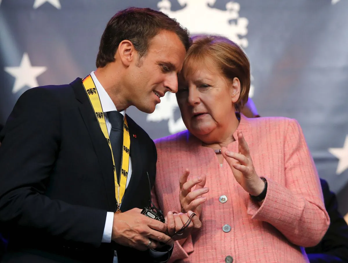 French President Emmanuel Macron speaks with German Chancellor Angela Merkel after being awarded the Charlemagne Prize for "European vision" in Aachen, Germany, on May 10, 2018. (Reuters/Wolfgang Rattay/File Photo)