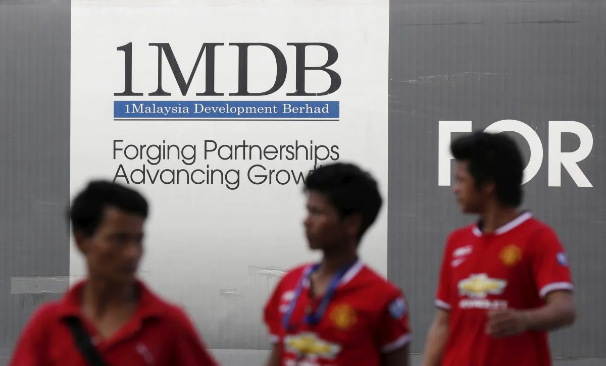 Men walk past a 1Malaysia Development Berhad (1MDB) billboard at the fund's flagship Tun Razak Exchange development in Kuala Lumpur, on March 1, 2015. (Olivia Harris/Reuters)