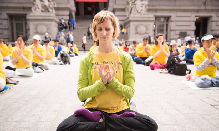 A woman who practices Falun Gong meditates with others near Battery Park in Manhattan during World Falun Dafa Day on May 13, 2015. (Laura Cooksey)