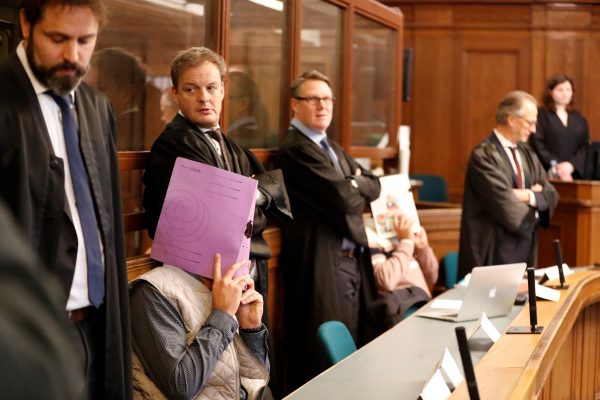 gold coin heist defendant hides his face in court