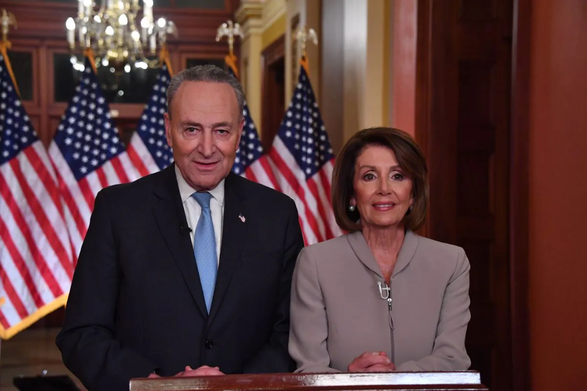 House Speaker Nancy Pelosi and Senate Democratic leader Chuck Schumer pose for pictures after delivering a response to President Donald Trump's televised address to the nation on border funding at the Capitol in Washington D.C. on Jan. 8, 2019. (NICHOLAS KAMM/AFP/Getty Images)