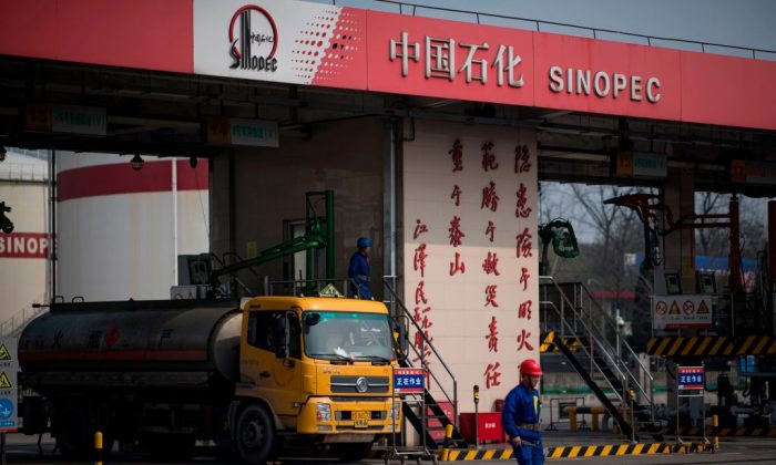 A man works at a gas station of Sinopec in Shanghai on March 22, 2018. (Johannes Eisele/AFP/Getty Images)