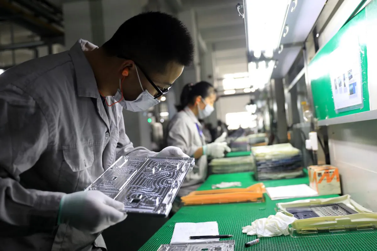 Workers check laptop parts in a factory in the Hangyong Auto Industrial Park, in Lu'an City, Anhui Province, China on Nov. 19, 2018. The factory produces equipment for Toshiba, Matsushita and other international brands. (STR/AFP/Getty Images)